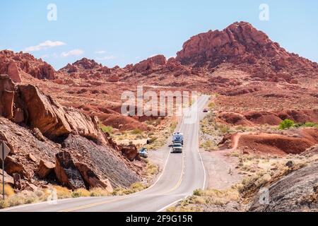 Vertical Road Going Downhill with Red Aztec sandstone and rock formation On Both Sides at Valley of Fire State Park in Nevada Stock Photo