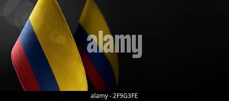 Small national flags of the Colombia on a dark background Stock Photo