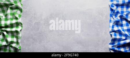 Folded checked or checkered tablecloth at stone surface of table. Top view as panorama of cloth napkin texture background with copy space Stock Photo
