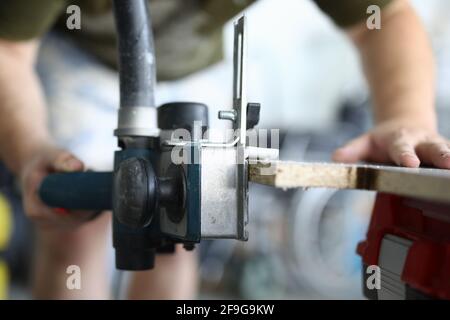 Close-up of male carpenter working with wooden plank Stock Photo