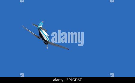 small single-propeller airplane flies in the clear blue sky flying high into the sky with copy space, nobody. Stock Photo