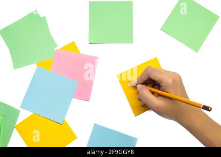 Female hand with a pencil and many blank stickers for writing isolated on a white background. Writing ideas Stock Photo
