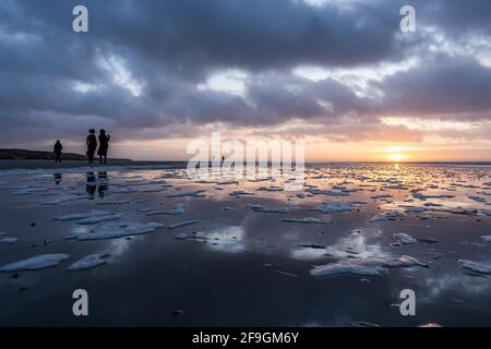 Couple taking photos at sunset on the beach, Langeoog, East Frisian Islands, Lower Saxony, Germany Stock Photo