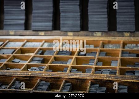 Printing press letter blocks in a wooden shelf. Stock Photo