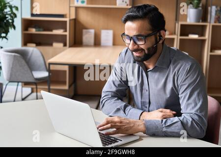 Smiling indian businessman having video call virtual meeting on laptop. Stock Photo