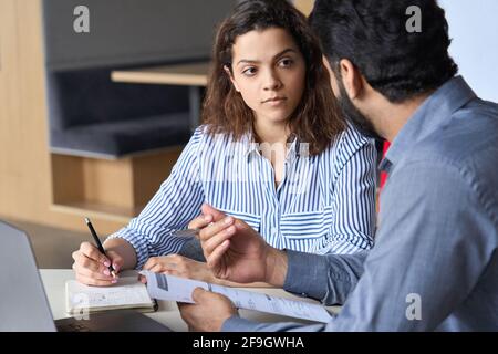 Mentoring Hispanic teacher and latin student working together on course work. Stock Photo