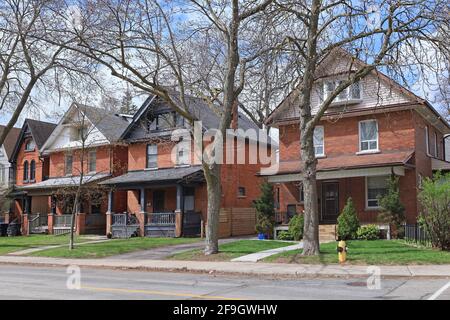 Street with row of large older brick detached houses with gables Stock Photo