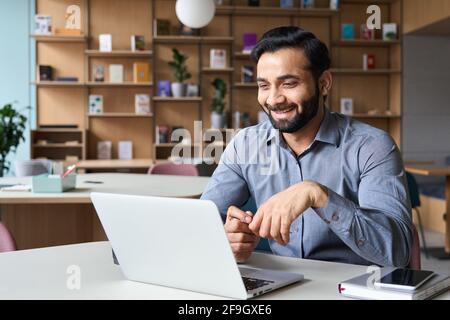 Smiling indian latin manager talking to employees virtual video meeting call. Stock Photo