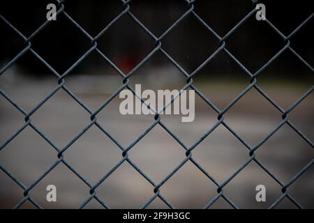 Chain link fence surrounding a dark restricted area in Speculator, NY USA Stock Photo
