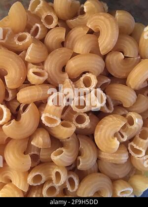 Dry elbow macaroni pasta noodles texture background Stock Photo
