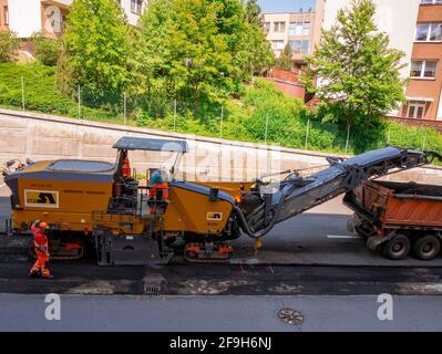 Usti nad Labem, Czech republic - 5.22.2018: Two road workers operate road milling machine Stock Photo