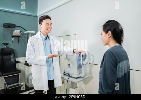 a male doctor wearing a uniform with a female patient in the examination room Stock Photo