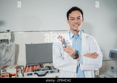 a young male doctor poses holding a trial frame Stock Photo