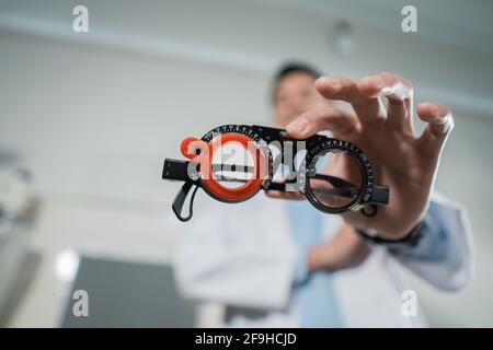 a trial frame is being held by a doctor Stock Photo