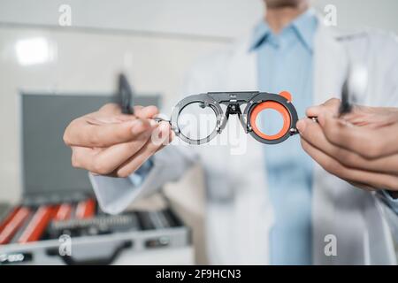 an adjustable axis trial frame is being held by a doctor in an eye clinic Stock Photo