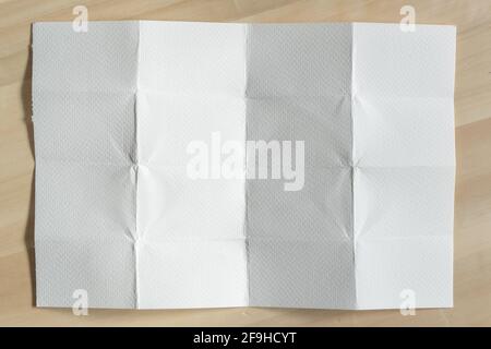 Folded white rough paper on wood background Stock Photo