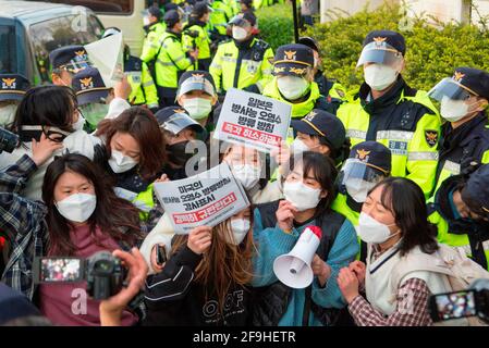 Students' protest against Japan to release water from Fukushima, Apr 17, 2021 : Policemen block college students trying to hold a press conference in front of the Japanese embassy in Seoul, South Korea, while their colleague protesters stage a sit-down demonstration in front of the embassy. They were protesting against the Japanese government's decision to discharge radioactive water from Fukushima. Signs read,'Japan cancel the decision to discharge radioactive water!' (top) and 'We strongly condemn U.S. administration that has expressed its support for the Japanese government's decision to di Stock Photo