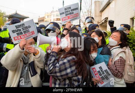 Students' protest against Japan to release water from Fukushima, Apr 17, 2021 : Policemen block college students trying to hold a press conference in front of the Japanese embassy in Seoul, South Korea, while their colleague protesters stage a sit-down demonstration in front of the embassy. They were protesting against the Japanese government's decision to discharge radioactive water from Fukushima. Signs read,'Japan cancel the decision to discharge radioactive water!' (L and bottom R) and 'We strongly condemn U.S. administration that has expressed its support for the Japanese government's dec Stock Photo