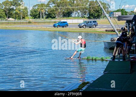 Mackay, Queensland, Australia - April 2021: Man learning to wakeboard at a cable ski park Stock Photo