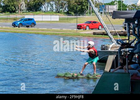 Mackay, Queensland, Australia - April 2021: Man learning to wakeboard at a cable ski park Stock Photo
