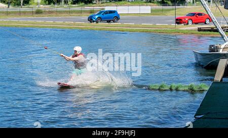 Mackay, Queensland, Australia - April 2021: Man learning to wakeboard at a cable ski park Stock Photo