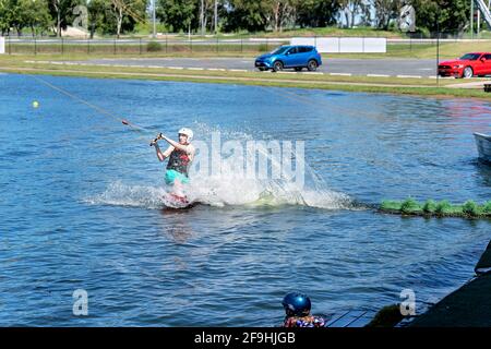 Mackay, Queensland, Australia - April 2021: Man learning to wakeboard at a cable ski park Stock Photo