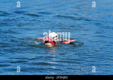 Mackay, Queensland, Australia - April 2021: Male learning to wakeboard at a cable ski park has fallen off and swimming to shore Stock Photo