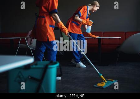 Two professional cleaners tidying up the office cafeteria Stock Photo