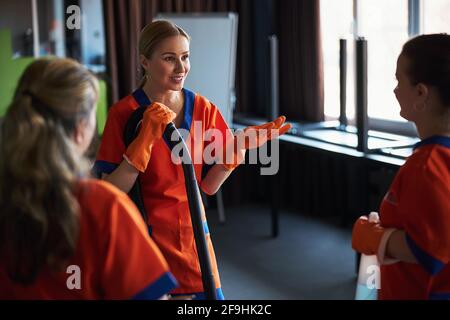 Female workers having a conversation during the office cleaning Stock Photo