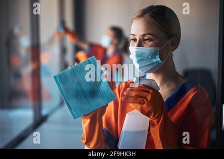 Woman wiping the glass surface with an absorbent cloth Stock Photo