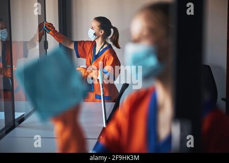 Janitorial staff washing the office glass walls Stock Photo