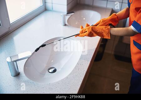 Qualified cleaning lady sanitizing the bathroom sink Stock Photo