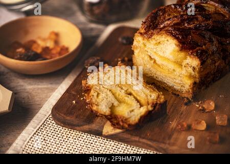 Homemade vanilla cream babka sliced on wooden cutting board Stock Photo