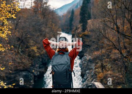 woman tourist stands on the bridge over the river or admires the nature landscape Stock Photo