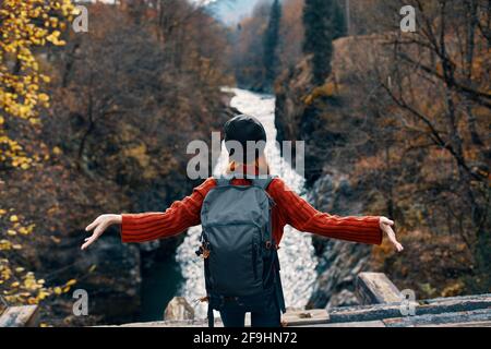 woman hiker stands on the bridge near the river mountains travel Stock Photo