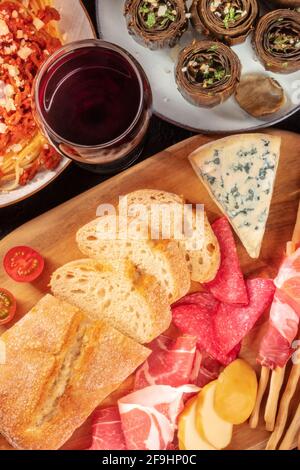 Italian antipasti with wine, shot from above. Bread, cheese, ham, artichokes Stock Photo