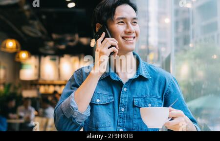 Asian man working at cafe on weekend Stock Photo