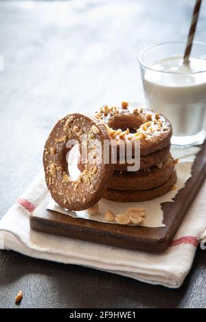 a stack of shortbread homemade cookies with peanuts on a wooden background with milk. peanut cookie. Stock Photo