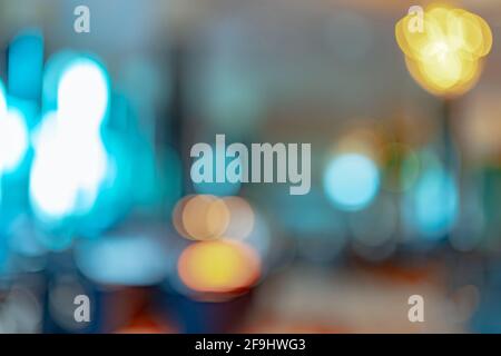 Blurred orange, yellow, and blue light bokeh abstract background. Defocused orange and white light on coffee shop or office interior. Bokeh background Stock Photo