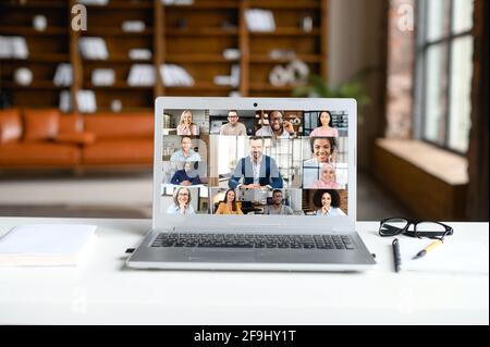 Laptop screen webcam view different ethnicity age people engaged in group videocall. Video conference lead by european businessman leader. Modern technology, easy convenient on-line meeting concept Stock Photo