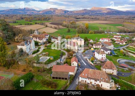 Drone view of residential homes with lawn in Le Pont de Beauvoisin, surrounded by agriculture land at foot of hills Stock Photo