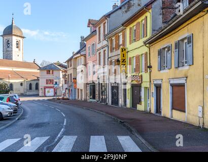 Beautiful street view featuring Pizza Place of a small town of France with church tower in backdrop. Stock Photo