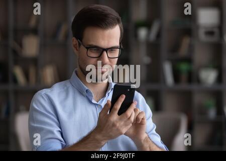 Millennial man use smartphone texting online on gadget Stock Photo