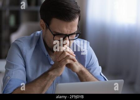 Unhappy man work on laptop frustrated with business problem Stock Photo