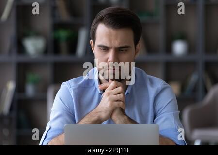 Pensive man work on laptop thinking of problem Stock Photo