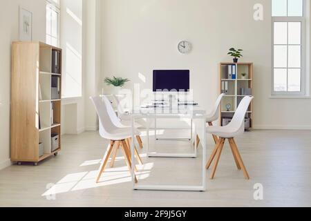 Interior of modern meeting room with big table, comfortable chairs and desktop computer Stock Photo