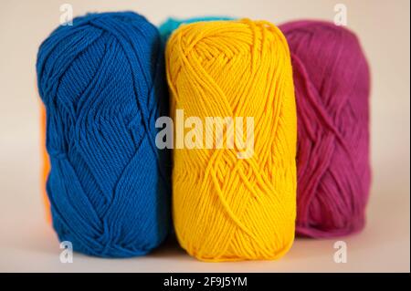 Mercerized cotton skeins in vivid color set against a bright background. Colorful cotton yarn balls selection displayed for creative weaving Stock Photo