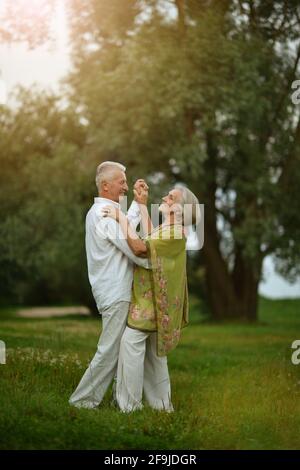 Happy senior couple dancing in the sun in summer in nature Stock Photo ...