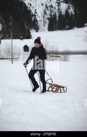 Climber pulls to top of wooden sled for ride on the piste. Going back ...