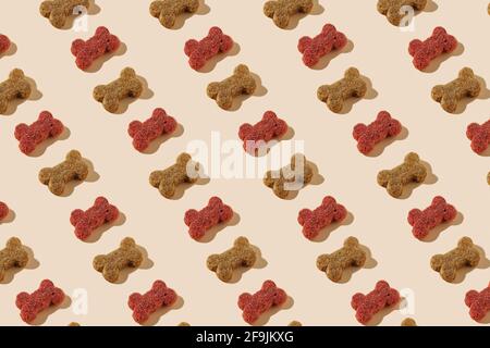 Modern pattern of dog food on beige background illuminated by bright summer sunlight - Pop art design minimal creative concept - Flat lay pet food com Stock Photo